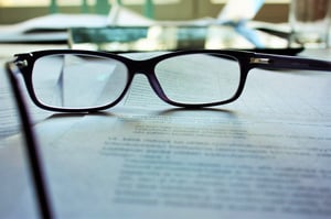 Gafas colocadas sobre el contrato de arrendamiento de una persona cansada de leer